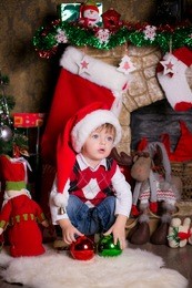 happy little boy near a christmas tree opening gifts
