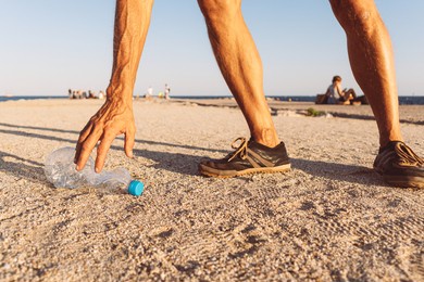 man picking up plastic bottle that pollute the sea, cleaning on the beach, campaign to clean volunteer concept
