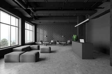 interior of spacious industrial style office with dark gray walls, concrete floor, reception desk with laptops and waiting room with armchairs, poufs and coffee tables. 3d rendering