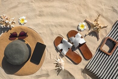 flat lay composition with different beach accessories on sand