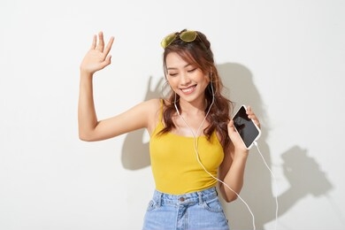 summer lady. beautiful asian girl singing and dancing while listening to music on white background