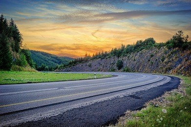 landscape with curvy road at summer sunset 