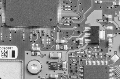 closeup of electronic circuit board with processor in black and white