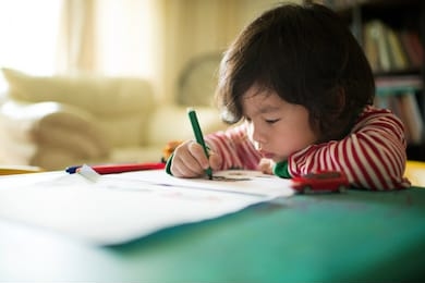 little asian chinese boy child kid writing and drawing on a table. preschooler. early learning. kindergarten homework. homeschooler art class. playschool at home. gifted student. day activity. 