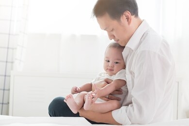 young happy asian dad and newborn baby infant boy playing at sweet home. unconditional love.