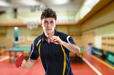 young man tennis-player in play on sport club background