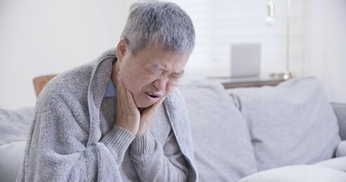 asian elderly man has sore throat and feel very uncomfortable at home