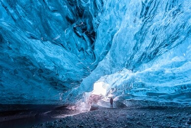 tourist standing in an ice cave in iceland