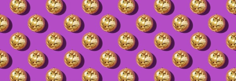 creative christmas pattern. shiny gold disco balls over violet background. flat lay, top view. new year baubles, star sparkles. party time. cristmas greeting card.