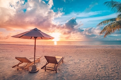 beautiful tropical sunset scenery, two sun beds, loungers, umbrella under palm tree. white sand, sea view with horizon, colorful twilight sky, calmness and relaxation. inspirational beach resort hotel