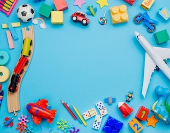 frame of kids toys on blue background with blank space for text. top view, flat lay.