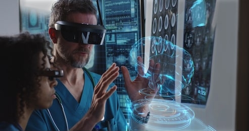 medium close-up of a male and a female doctor examining 3d brain hologram while wearing vr headsets