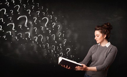 confused woman reading a book with question marks coming out from it