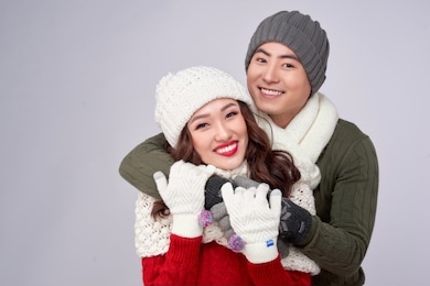 happy young lovers in knitted woolen clothing hugging and looking together.