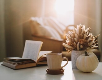 autumn still life. coffee cup, flowers, book and pumpkin. hygge lifestyle, cozy autumn mood. flat lay, happy thanksgiving background
