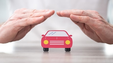 car protected by hands - concept of auto insurance