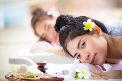 two young asian women relaxing in spa salon. beauty service with friends on spa bed.ladies relax with happy face. luxury beauty skin treatment concept.