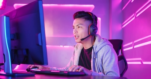 young asian handsome pro gamer playing in online video game