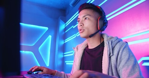 young asian handsome pro gamer having live stream and playing in online video game