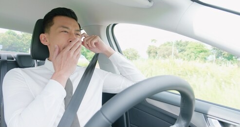 business asian man yawn in an autonomous self driving car