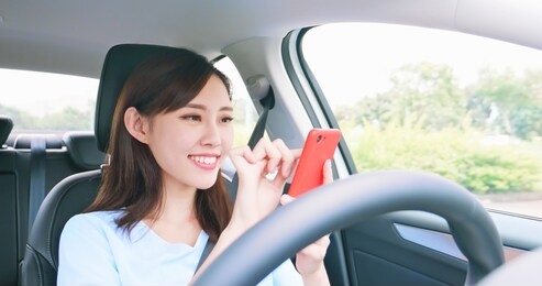 asian woman experience to riding an autonomous self driving car and use smart phone