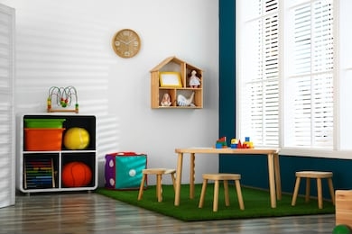 stylish playroom interior with wooden table and stools