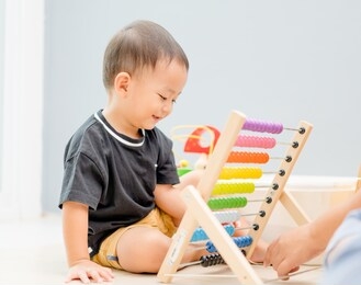 little toddler asian cute handsome boy using the abacus with colorful beads to learn how to count at home.portrait of little toddler boy with mother using abacus.brain, thinking, child development.