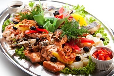 seafood - prawns, squids, scallops, mussels, fillet of salmon, crawfish, greens and lemon