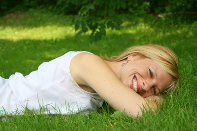 smiling woman relaxes on the grass