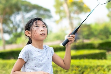 asian girl playing badminton outdoor.