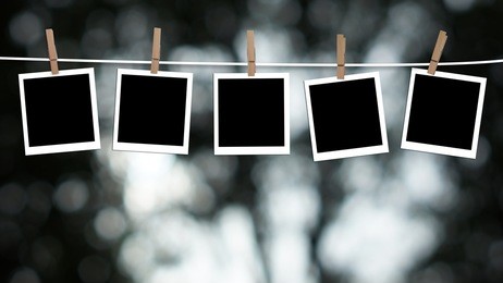 blank photographs hanging on a clothesline against a bokeh lights background