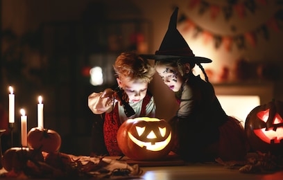 happy children in costumes of witch and vampire  in a dark house in   holiday halloween
