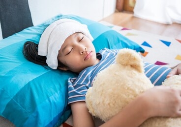 sick little girl sleeping in bed room at home,compress on forehead.