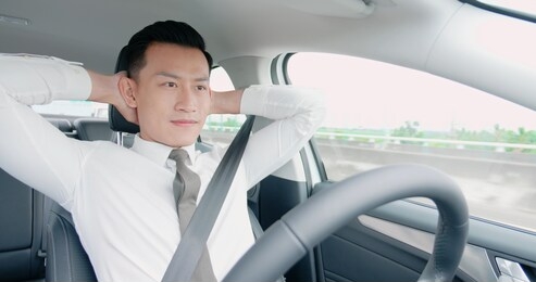 confident business asian man enjoy to drive an auto self-driving smart car in highway