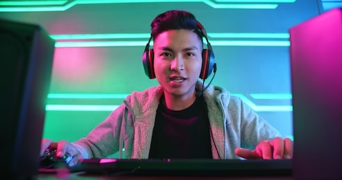 young asian handsome pro gamer playing in online video game