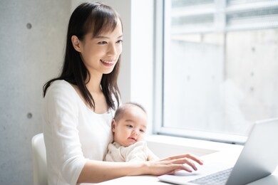 young woman using laptop computer with her baby