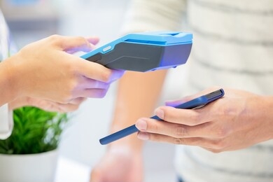mobile payment concept - close up of pay bills by phone to credit card system