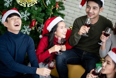 a group of asian are drinking wine, talking more fun to celebrate christmas.