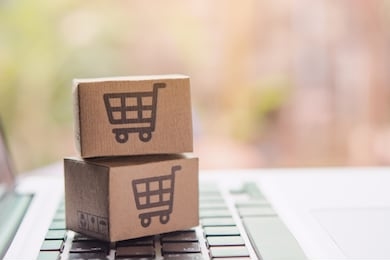 online shopping - paper cartons or parcel with a shopping cart logo on a laptop keyboard. shopping service on the online web and offers home delivery.