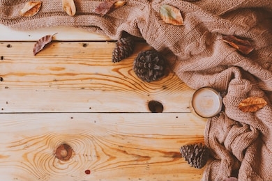 autumn background. a cup of hot coffee, knitted scarf and pinecones on wooden table. autumn coffee. knitted woolen sweater, coffee and fall leaves over rustic wood board. top view. copy space