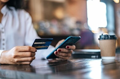 pay for goods by credit card through a smartphone in a coffee shop.
