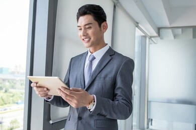 young business people standing in office thinking about work project. he is holding tablet concentrate on new job.