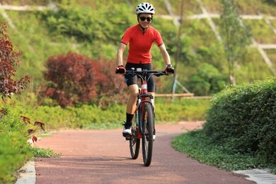 woman cyclist riding mountain bike outdoors