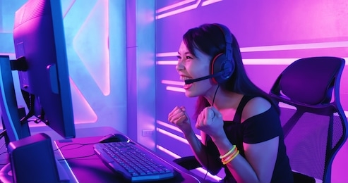 young asian pretty pro gamer win in online video game