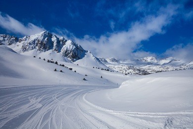 fresh ski slope and mountains in sunny day