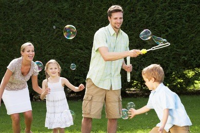 family playing with bubbles in garden