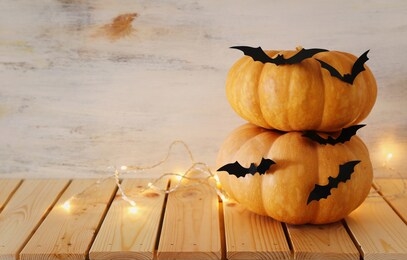 holidays halloween image. pumpkins and bats over wooden white table