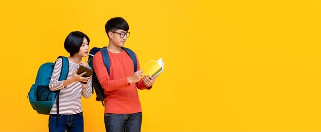 young asian male and female students in colorful casual clothes looking at the book  isolated yellow banner background with copy space for eduction concept