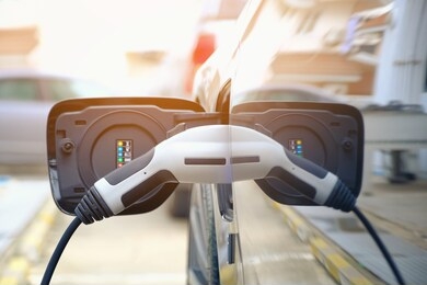 charging modern electric car battery on the street which are the future of the automobile, close up of power supply plugged into an electric car being charged for hybrid . new era of vehicle fuel.