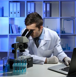 young laboratory scientist  looking at microscope in lab 